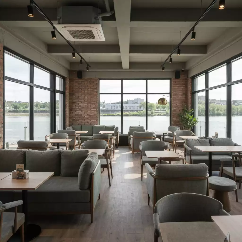 Modern cafe interior with river views, comfortable seating, and natural light